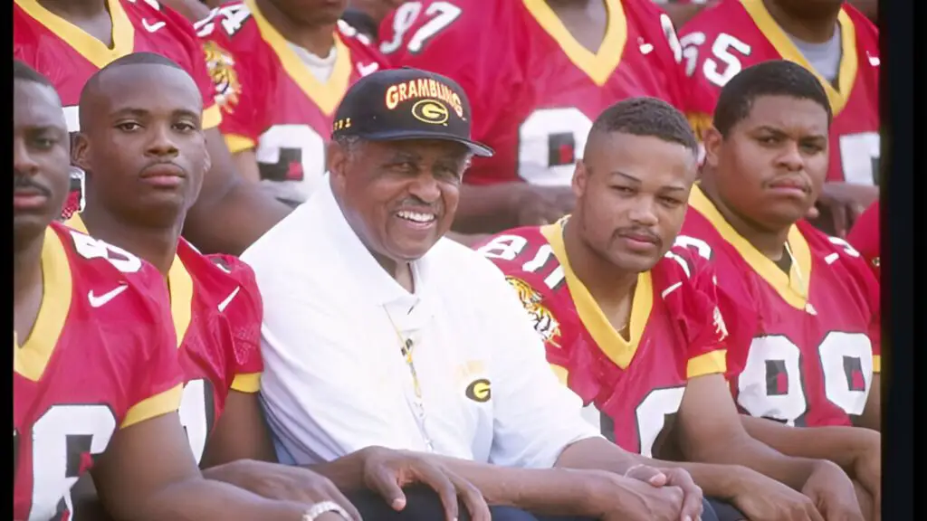 Former Grambling State head football coach Eddie Robinson sits with his team during Media Day