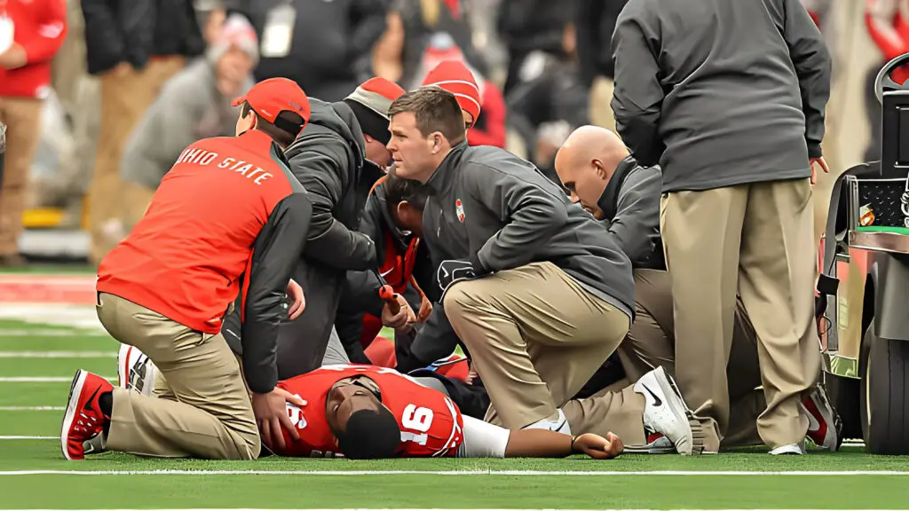 Doctors and trainers attend to Ohio State Buckeyes quarterback J.T. Barrett after Barrett injured his ankle against the Michigan Wolverines