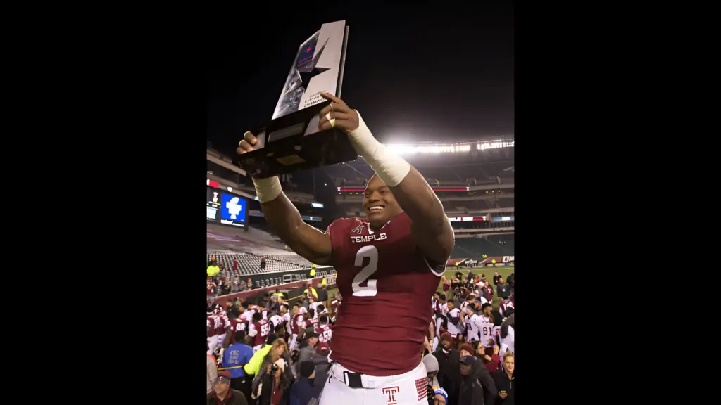 Temple Owls player Avery Williams holds up the American Athletic Conference East Division trophy after the game against the East Carolina Pirates