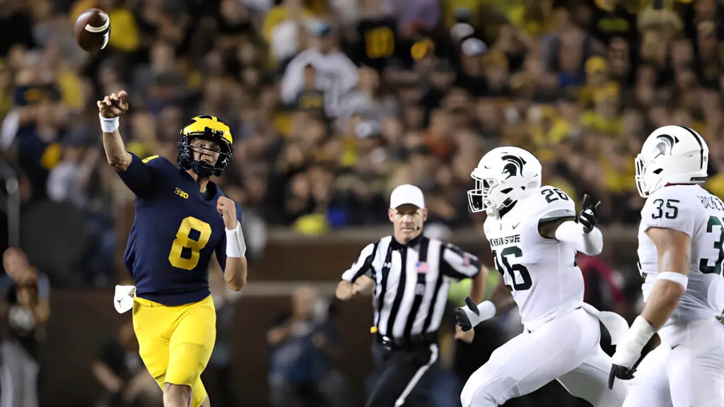 Michigan Wolverines quarterback John O'Korn rolls out and makes the pass during the third quarter of the game against the Michigan State Spartans