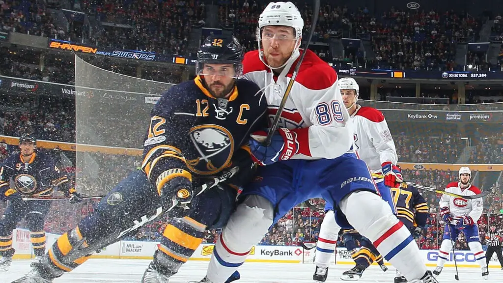 Buffalo Sabres captain Brian Gionta battles Montreal Canadiens player Nikita Nesterov for the puck during an NHL game