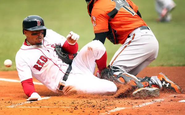 Mookie Betts is seen here sliding into home plate, colliding with Baltimore Orioles catcher Chance Sisco (Getty Images)