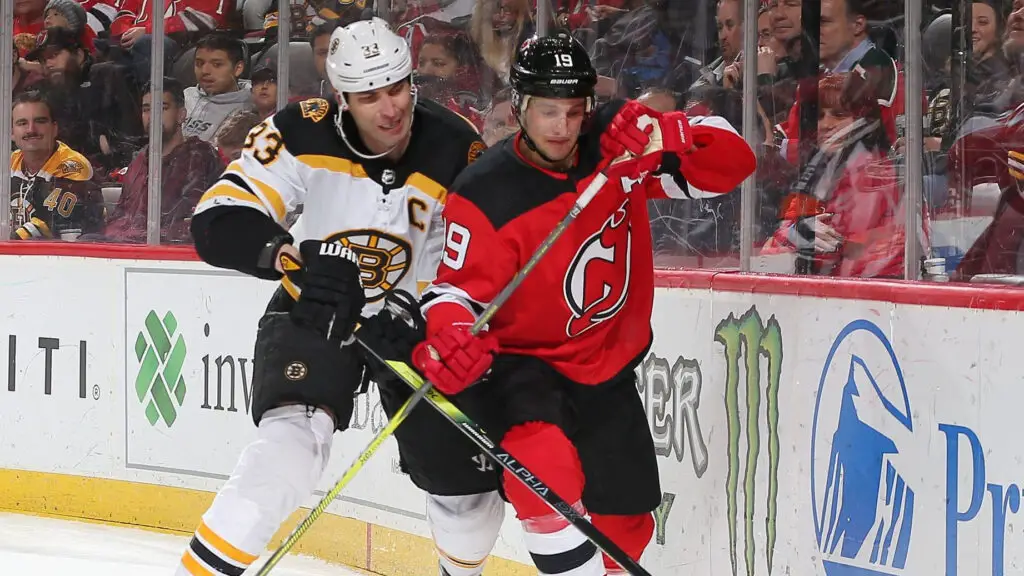 Boston Bruins player Zdeno Chara battles New Jersey Devils player Travis Zajac for possession of the puck during the third period