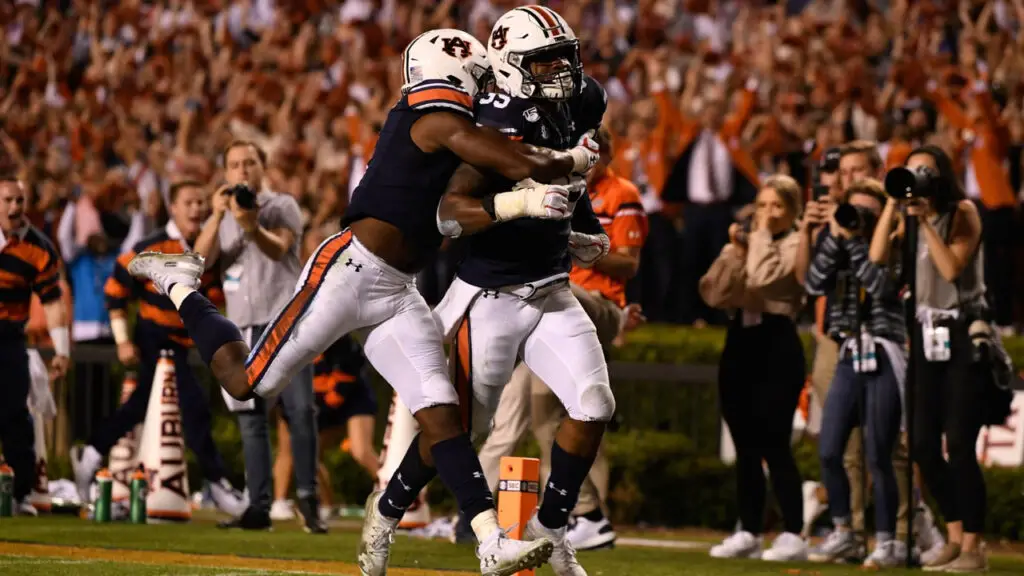 Auburn Tigers player Zakoby McClain is tackled by a teammate after returning a 100-yard interception for a touchdown against the Alabama Crimson Tide