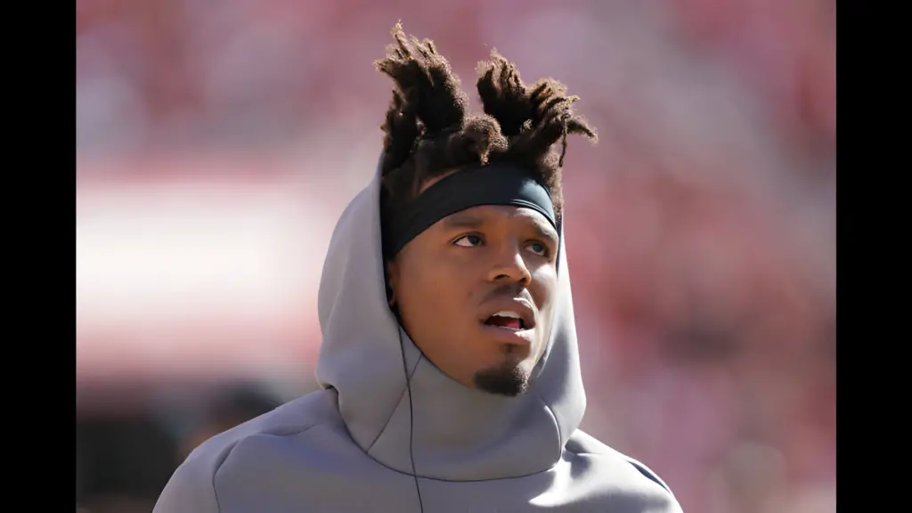 Former Carolina Panthers quarterback Cam Newton looks on from the sidelines against the San Francisco 49ers during an NFL football game