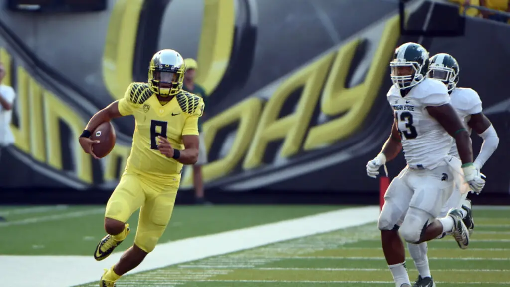 Former Oregon Ducks quarterback Marcus Mariota carries the football against the Michigan State Spartans