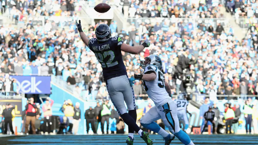 Former Seattle Seahawks tight end Luke Willson attempts to make a reception as Luke Kuechly defends against the Carolina Panthers in the 2016 NFC Divisional Playoff Game