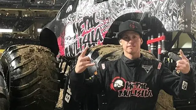 Action Sports competitor Matt Buyten gives a rock-on sign before a Monster Truck event