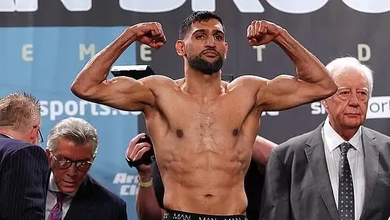 Boxer Amir Khan flexes after doing a weigh-in before his fight with Kell Brook