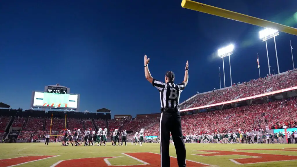 A referee signals that a point is good during a college football game