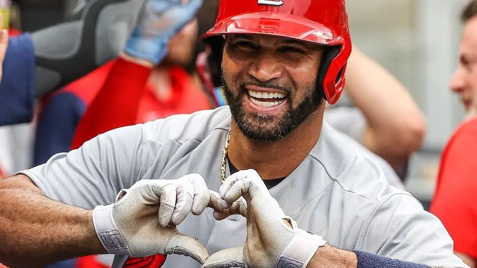 St. Louis Cardinals slugger Albert Pujols celebrates in the dugout by giving a heart signal in a game
