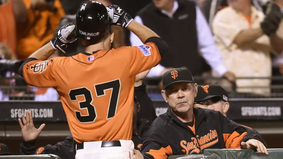 Former San Francisco Giants manager Bruce Bochy prepares to congratulate Kelby Tomlinson as he enters the dugout after he scored against the San Diego Padres