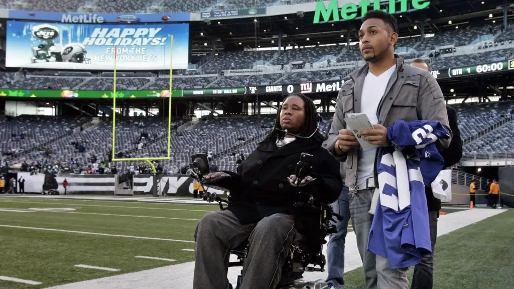 Former Rutgers Scarlet Knights player Eric LeGrand watches practice from the sidelines prior to the game between the New York Giants and the New York Jets