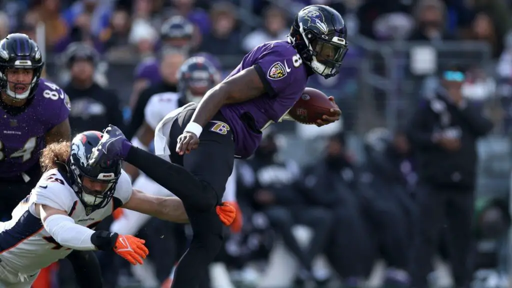 Baltimore Ravens quarterback Lamar Jackson avoids a tackle by Alex Singleton against the Denver Broncos