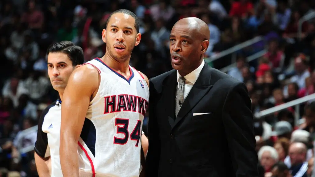 Atlanta Hawks head coach Larry Drew speaks with Devin Harris during the game against the Indiana Pacers during Game Six of the Eastern Conference Quarterfinals in the 2013 NBA Playoffs