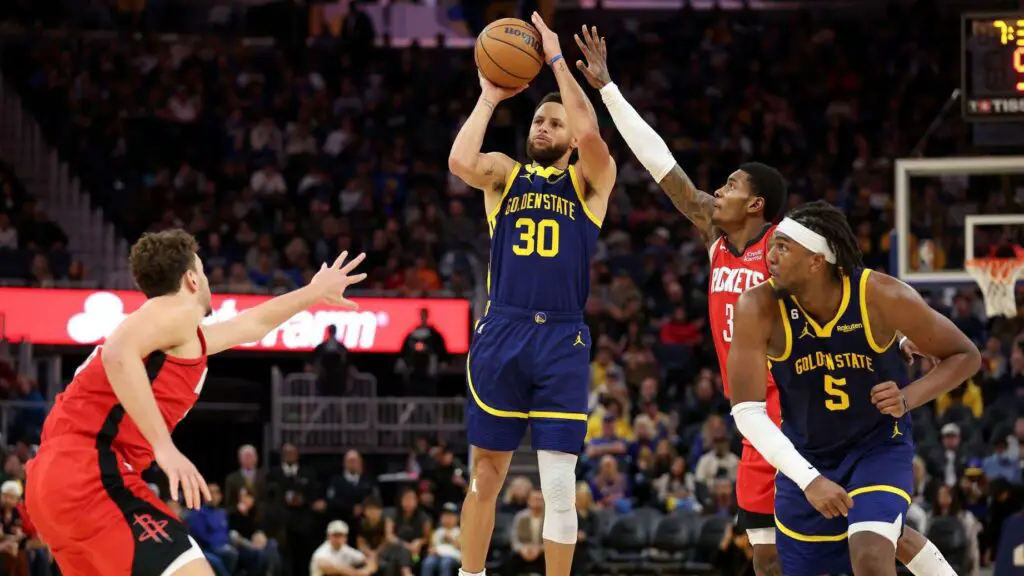 Golden State Warriors star Stephen Curry shoots over Kevin Porter Jr. against the Houston Rockets