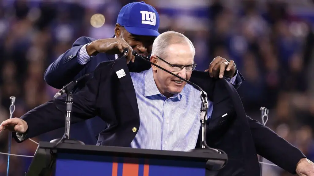 Former New York Giants defensive end Michael Strahan puts a jacket on 2016 Giants Ring of Honor inductee Tom Coughlin during the halftime ceremony of the game between the Cincinnati Bengals and the New York Giants