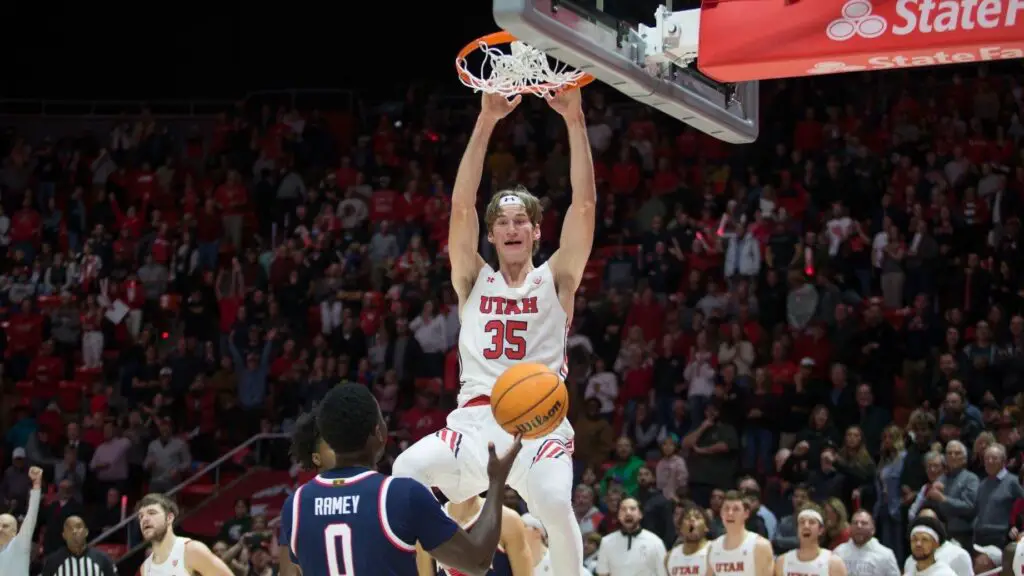 Utah Utes player Branden Carlson dunks over Courtney Ramey against the Arizona Wildcats during the second half of their game 