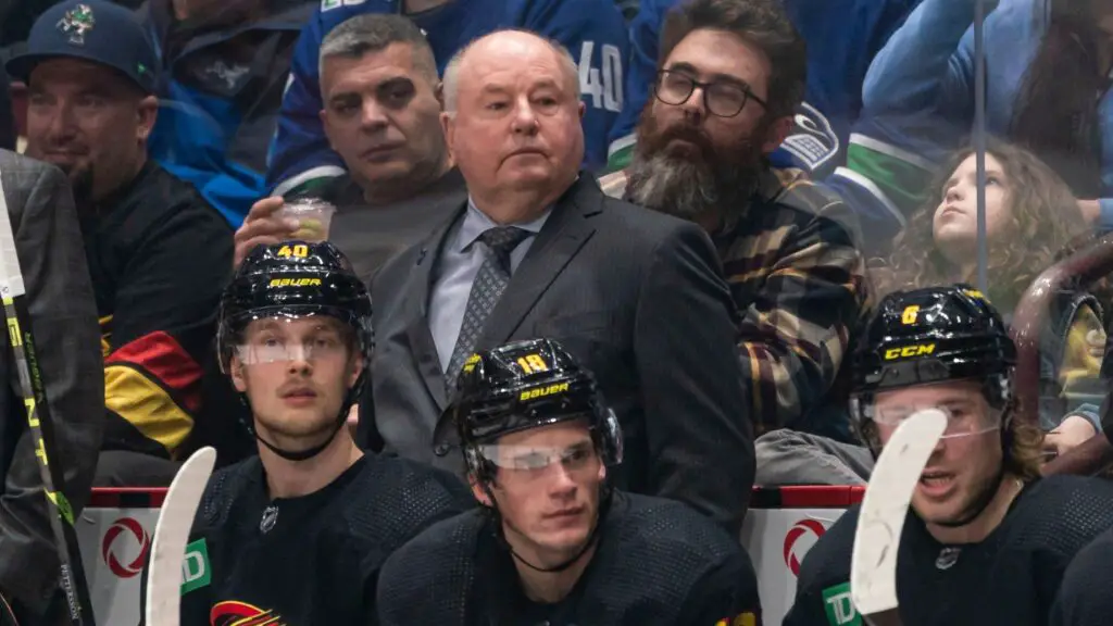 Former Vancouver Canucks head coach Bruce Boudreau watches his team play against the Edmonton Oilers during the first period in NHL action