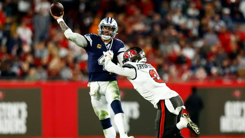 Dallas Cowboys quarterback Dak Prescott attempts to throw a pass as Joe Tryon-Shoyinka attempts to tackle him against the Tampa Bay Buccaneers in the fourth quarter of their NFC Wild Card Playoff Game