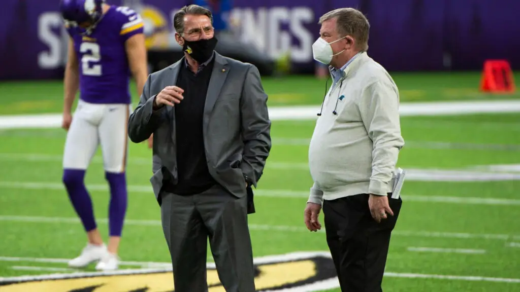 Former Carolina Panthers GM Marty Hurney and Minnesota Vikings GM Rick Spielman speak to one another before their game