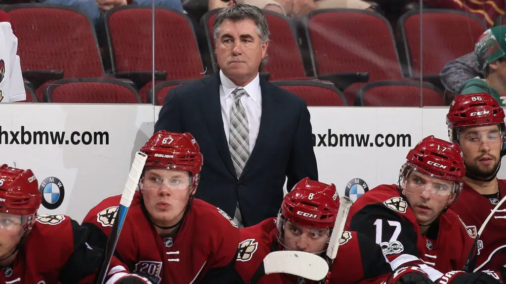 Arizona Coyotes head coach Dave Tippett watches from the bench during the third period of the NHL game against the Minnesota Wild