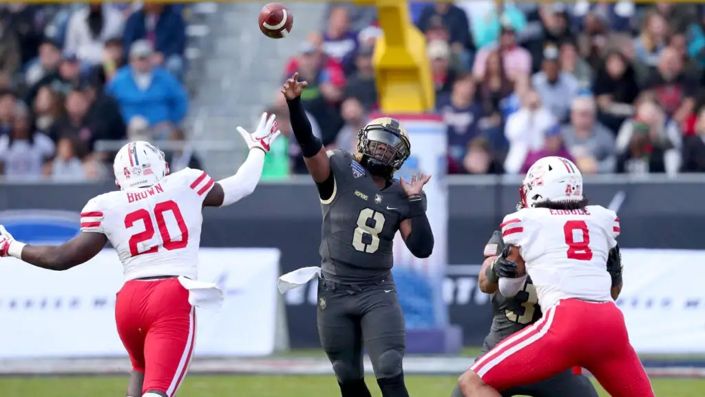 Army Black Nights quarterback Kelvin Hopkins Jr. looks for an open receiver as Roman Brown rushes him against Houston Cougars in the second quarter of the Lockheed Martin Armed Forces Bowl
