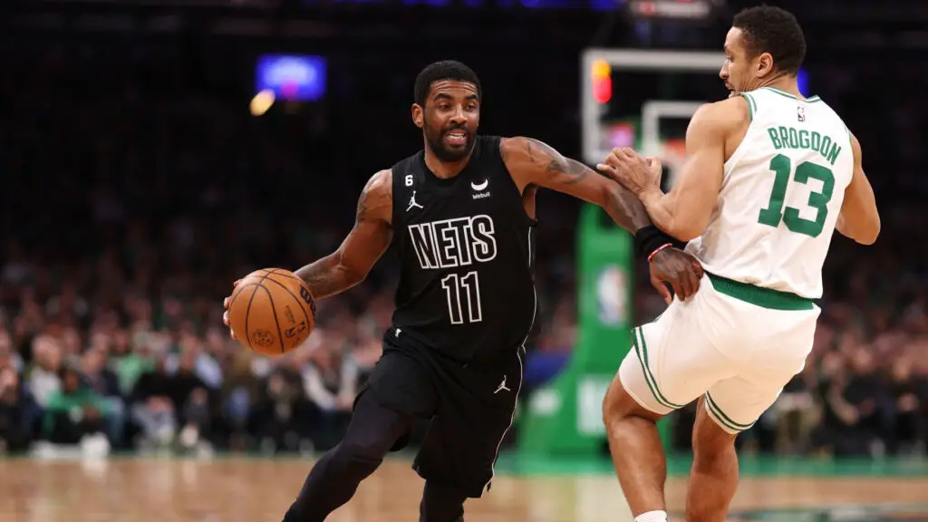 Brooklyn Nets star guard Kyrie Irving dribbles past Malcolm Brogdon against the Boston Celtics during the first half