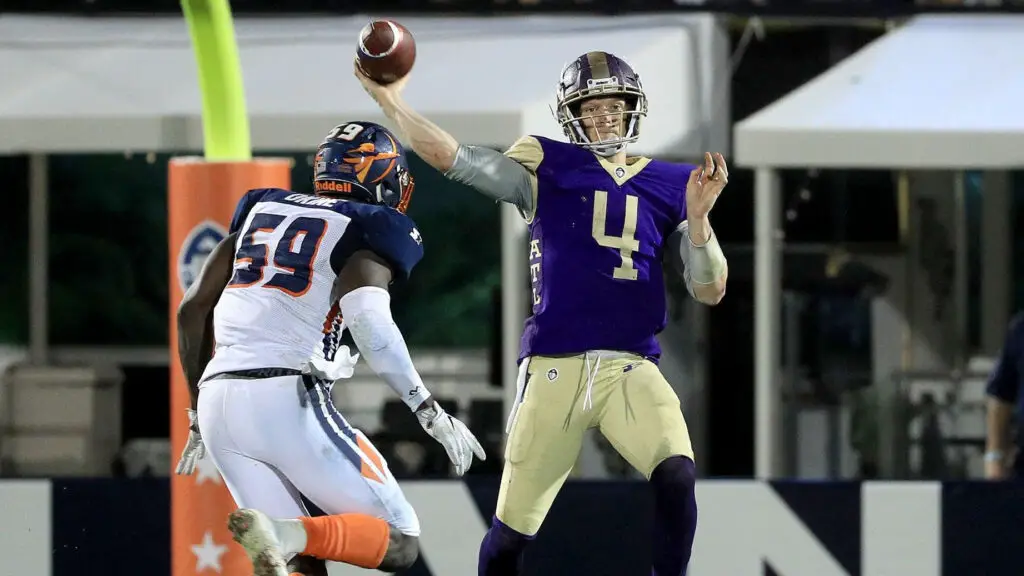 Atlanta Legends quarterback Matt Simms is hit as he throws the ball by Earl Okine against the Orlando Apollos during the fourth quarter