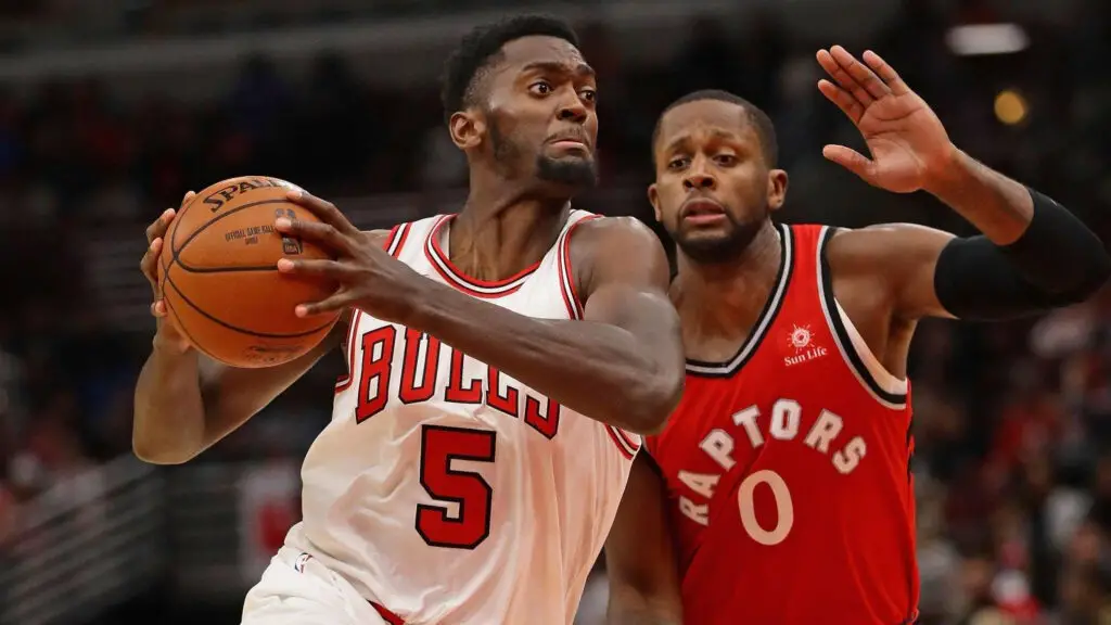 Chicago Bulls player Bobby Portis drives past CJ Miles against the Toronto Raptors during a preseason game