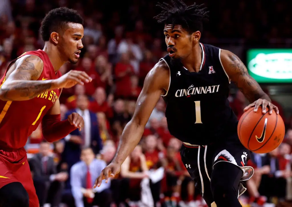 Cincinnati Bearcats player Jacob Evans drives the ball while Nick Weiler-Babb puts pressure on him against the Iowa State Cyclones in the second half of play