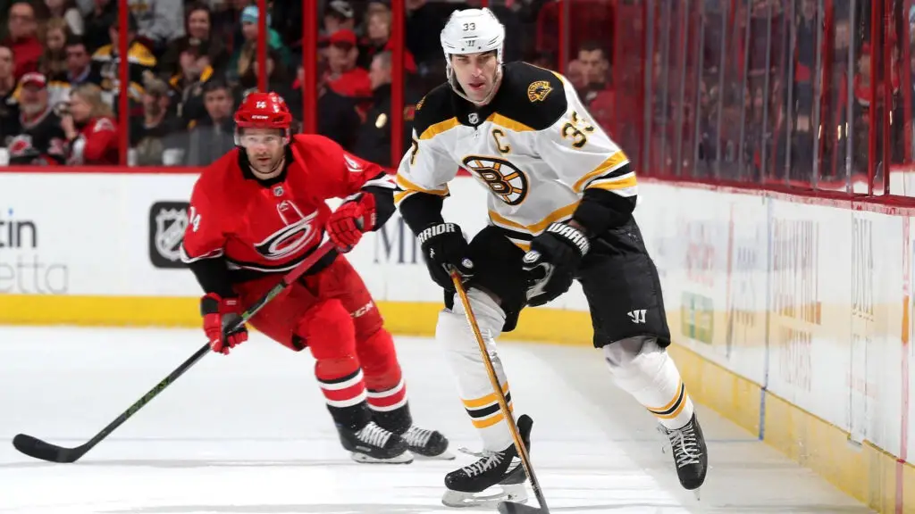 Boston Bruins defenseman Zdeno Chara skates for a loose puck as Justin Williams pursues him against the Carolina Hurricanes during an NHL game