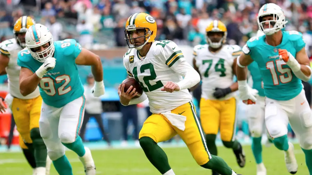 Former Green Bay Packers quarterback Aaron Rodgers carries the ball against the Miami Dolphins during the first quarter of the game