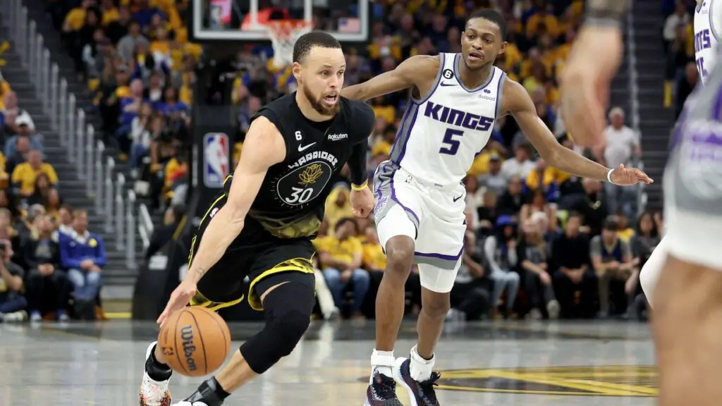 Golden State Warriors superstar Stephen Curry dribbles past De'Aaron Fox of the Sacramento Kings in the second half of Game Three of the Western Conference First Round Playoffs