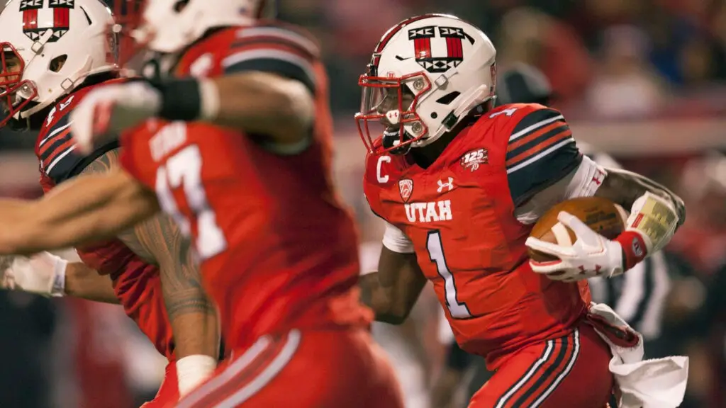 Utah Utes quarterback Tyler Huntley runs with the ball with his offensive line out front against the Arizona Wildcats during their game