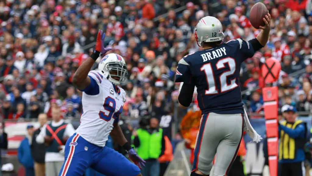 New England Patriots quarterback Tom Brady throws a pass over Mario Williams against the Buffalo Bills during the first half