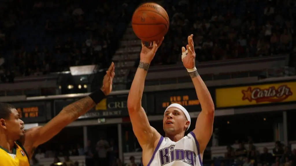 Former Sacramento Kings guard Mike Bibby attempts a shot over Earl Watson against the Seattle SuperSonics