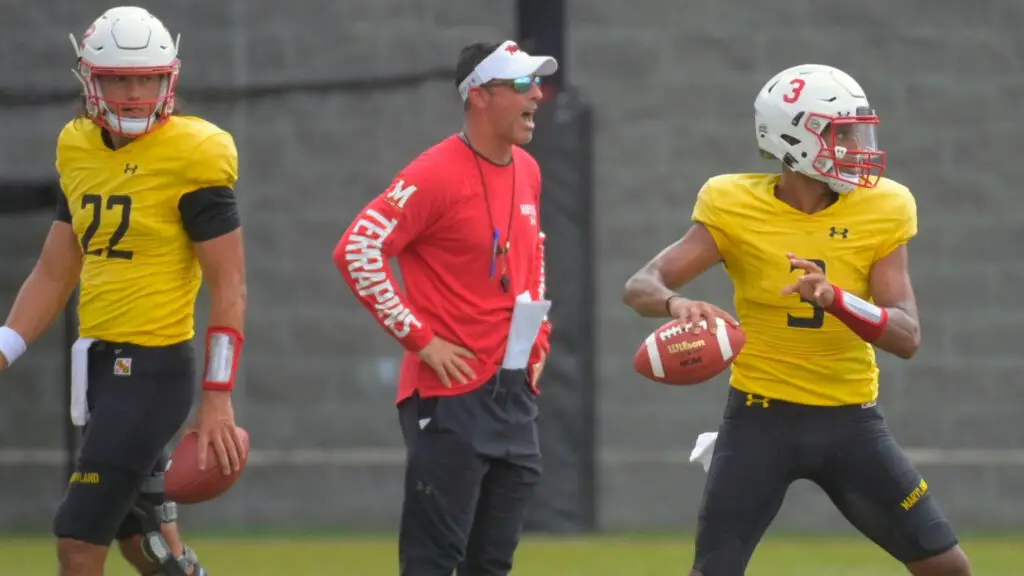 Former Maryland Terrapins offensive coordinator Dan Enos working with quarterbacks Eric Najarian and Taulia Tagovailoa during the Terrapins summer football practice at the Jones-Hill House fields