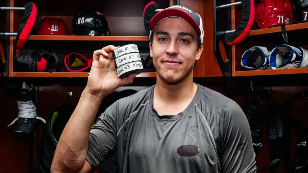 Carolina Hurricanes player Teuvo Teravainen poses in the locker room with the three pucks from his hat trick against the San Jose Sharks