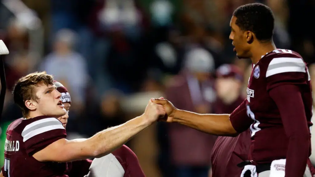 Mississippi State Bulldogs quarterback Nick Fitzgerald shakes hands with fellow quarterback Keytaon Thompson as he is carted off the field during the first half of an NCAA football game against the Mississippi Rebels