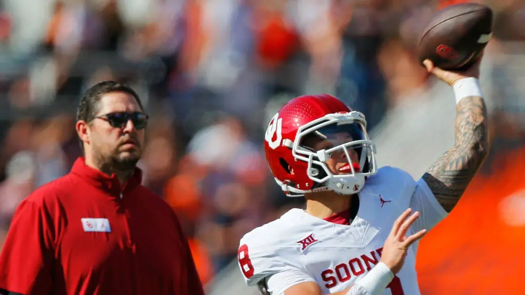 Oklahoma Sooners quarterback Dillon Gabriel throws a pass as offensive coordinator Jeff Lebby watches before a Bedlam game against the Oklahoma State Cowboys