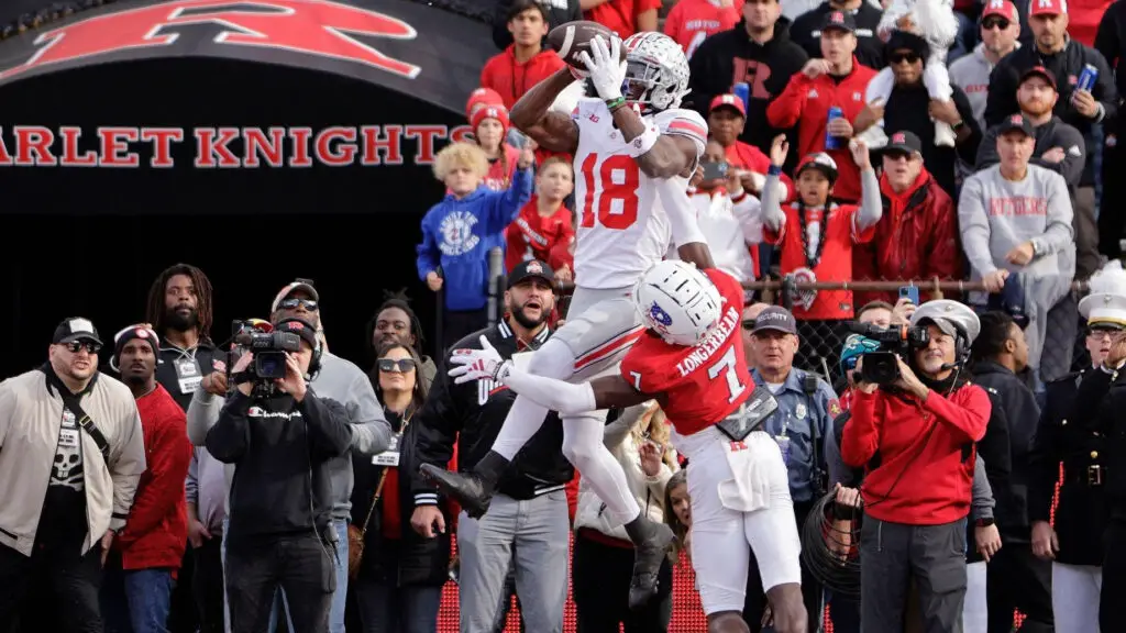 Ohio State Buckeyes wide receiver Marvin Harrison Jr. jumps over Rutgers Scarlet Knights defensive back Robert Longerbeam to make a touchdown catch during the fourth quarter of a college football game
