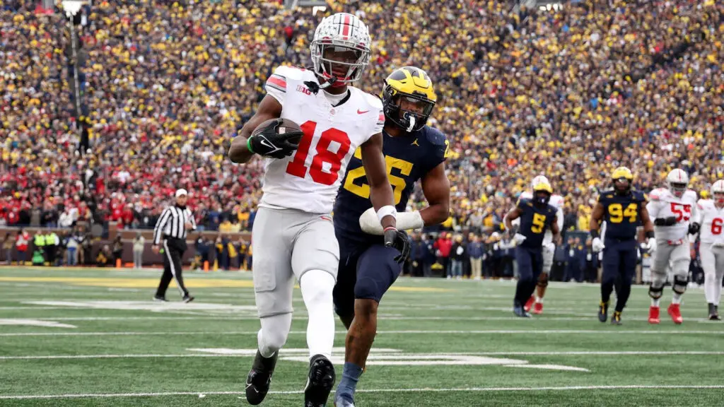 Ohio State Buckeyes wide receiver Marvin Harrison Jr. scores a touchdown against Michigan Wolverines defensive player Junior Colson during the fourth quarter in the game