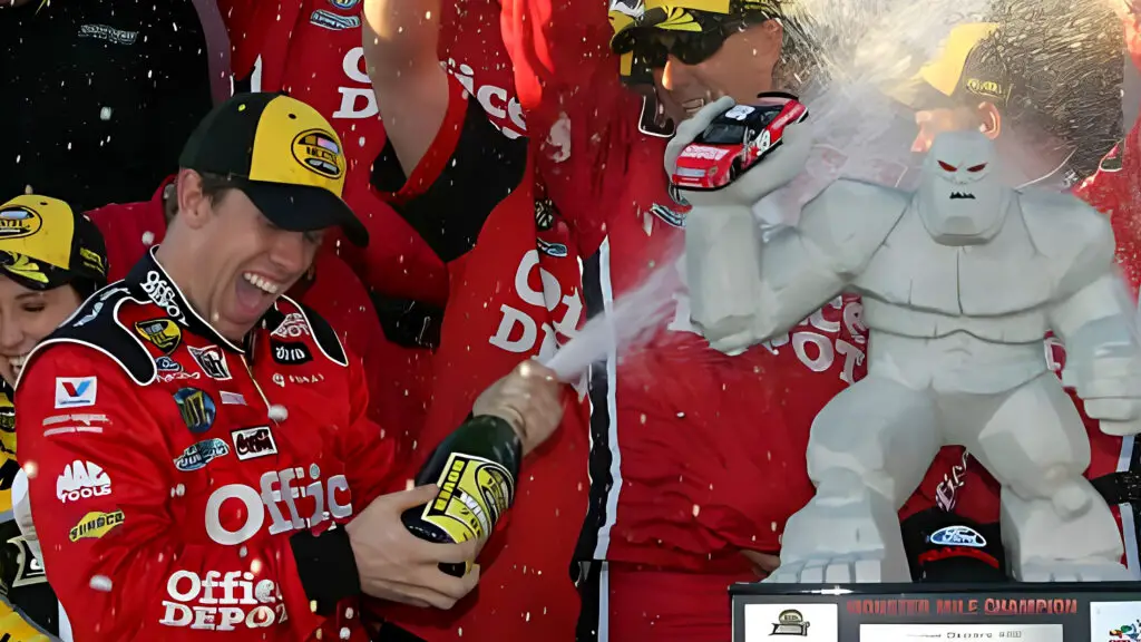Carl Edwards celebrates with his crew members in victory lane after winning the NASCAR Nextel Cup Series Dodge Dealers 400