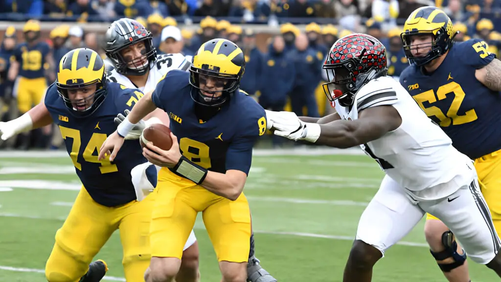 Michigan Wolverines quarterback John O'Korn scrambles away from trouble during Michigan's 31-20 loss to Ohio State in a college football game