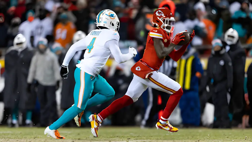 Kansas City Chiefs wide receiver Rashee Rice runs with the football as Miami Dolphins defensive player Kader Kohou tries to tackle him during an NFL wild-card playoff football game