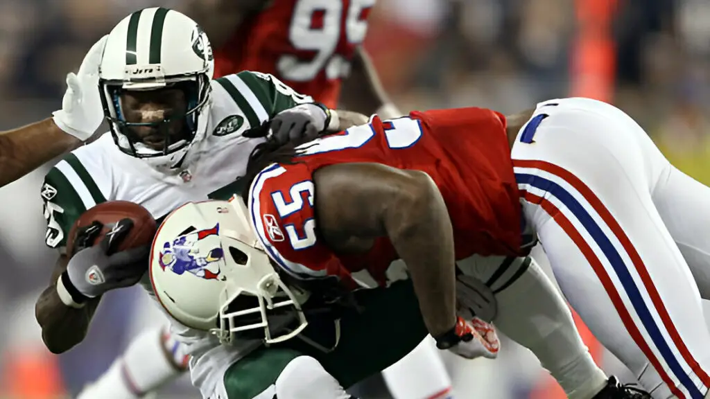 New England Patriots defensive player Brandon Spikes tackles New York Jets wide receiver Derrick Mason during their game