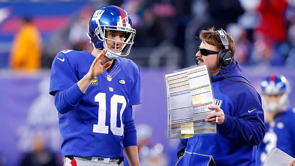 New York Giants quarterback Eli Manning talks to offensive coordinator Ben McAdoo during a game against the Carolina Panthers