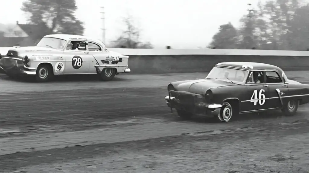 Race car driver Dick Passwater passes Ralph Ligouri, who is having a tire issue with his 1953 Lincoln, during a NASCAR Cup race