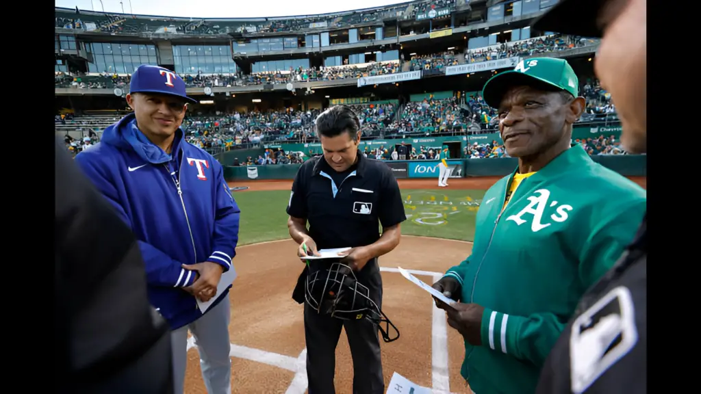 Former Texas Rangers associate Manager Will Venable and Oakland Athletics Special Assistant to the President Rickey Henderson exchange lineup cards before the game against the Oakland Athletics